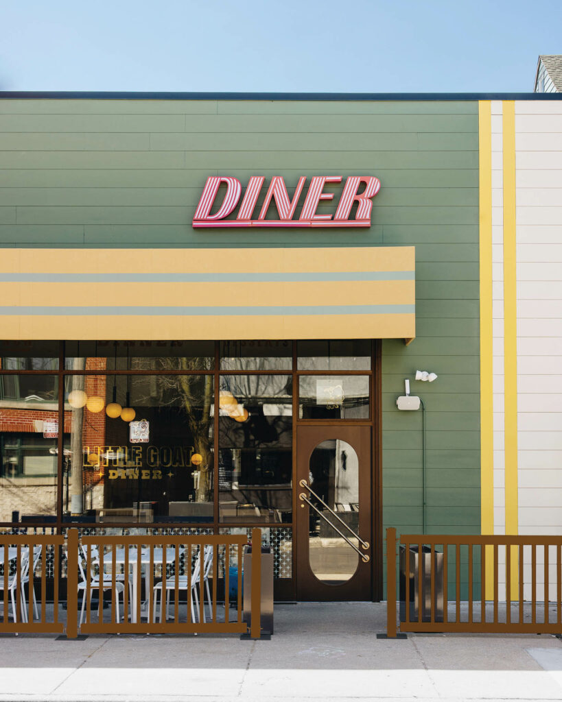 The exterior of a diner with signage and green and yellow facade