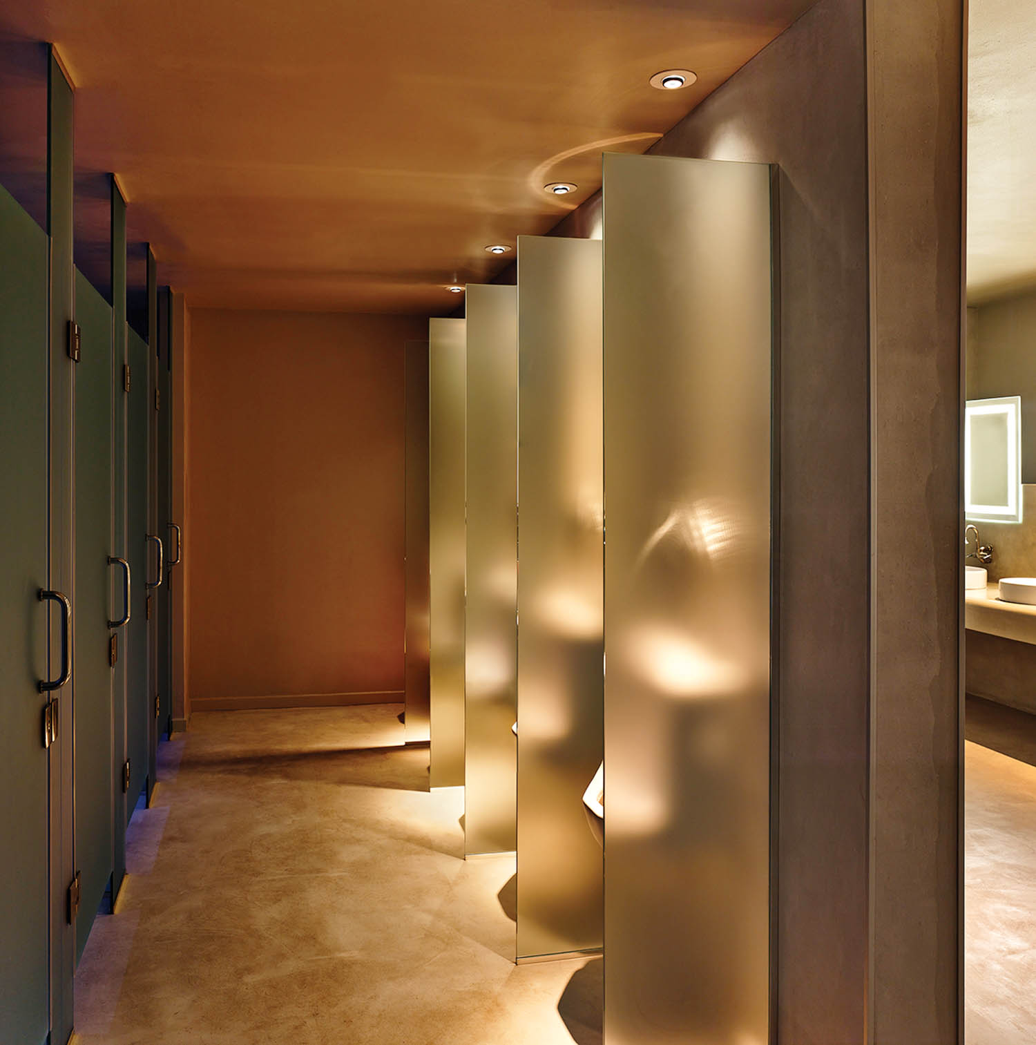 bathroom with green stalls and frosted glass by windows