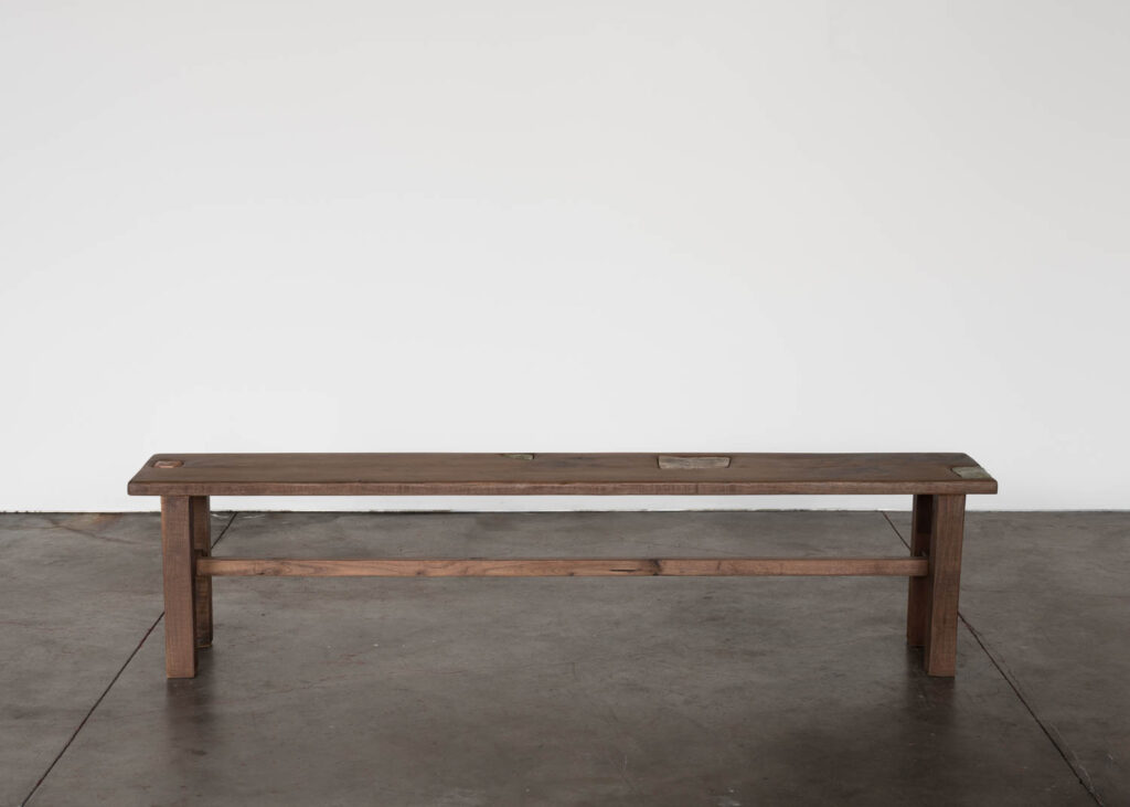 lone wooden bench in a gallery space