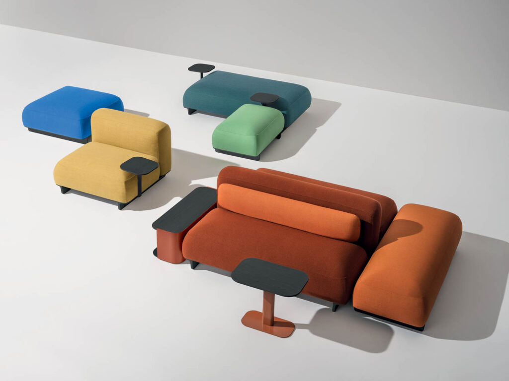 assortment of different colored armchairs with attached tables