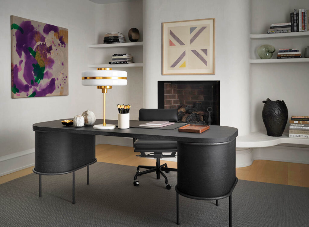 home office in the corner of the bedroom with black desk and chair