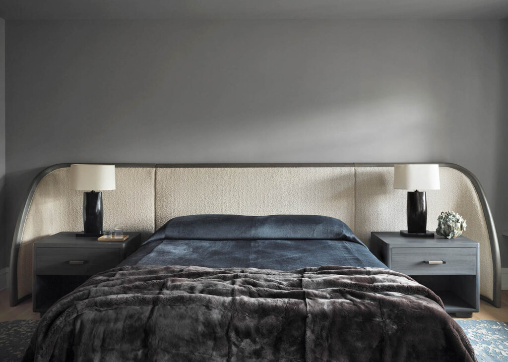 bedroom with dark blue bed with black silk sheets and white headboard