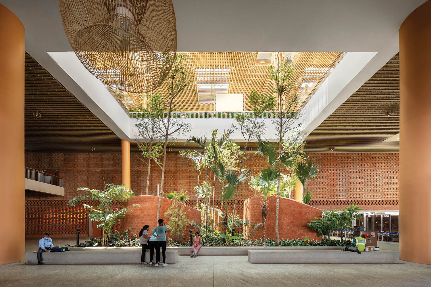 Botanical park area in the middle of the terminal with lots of greenery  and red walls