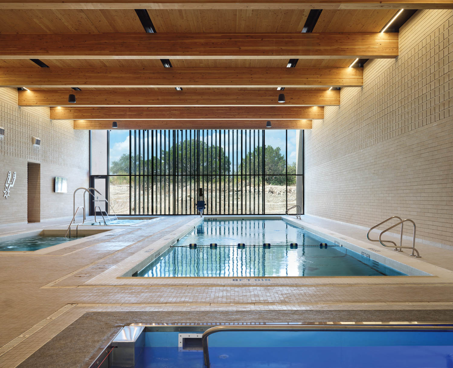 pool area with high beam ceilings, swimming pool and black fenced gate