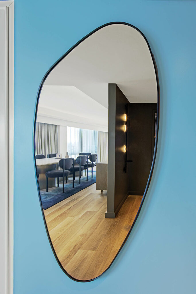 custom mirror in a suite against a blue wallcovering