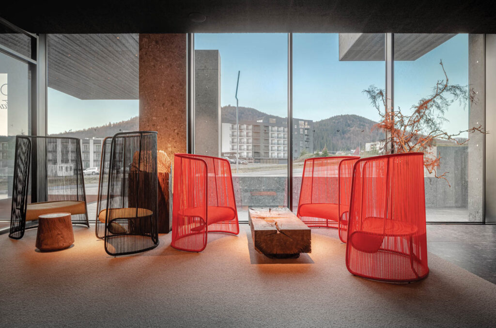 reception area with red and black wire-framed chairs with outdoor views