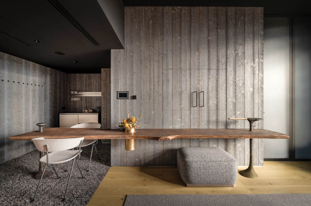 office space with custom wood table, grey chairs and paneled walls